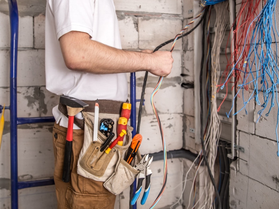electrician-working-near-board-with-wires-installation-connection-electrics-min
